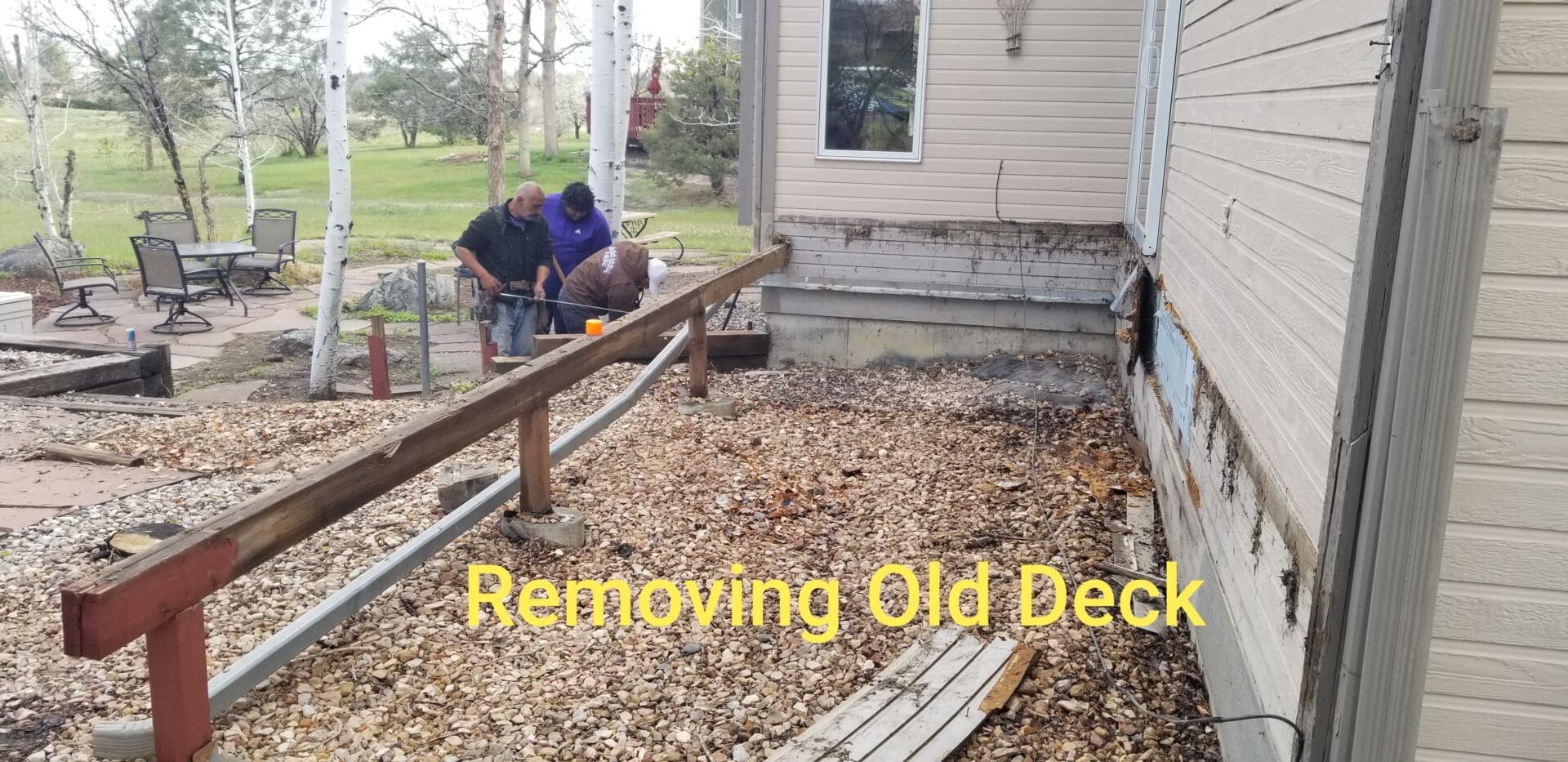 A man and woman working on the deck of their home.