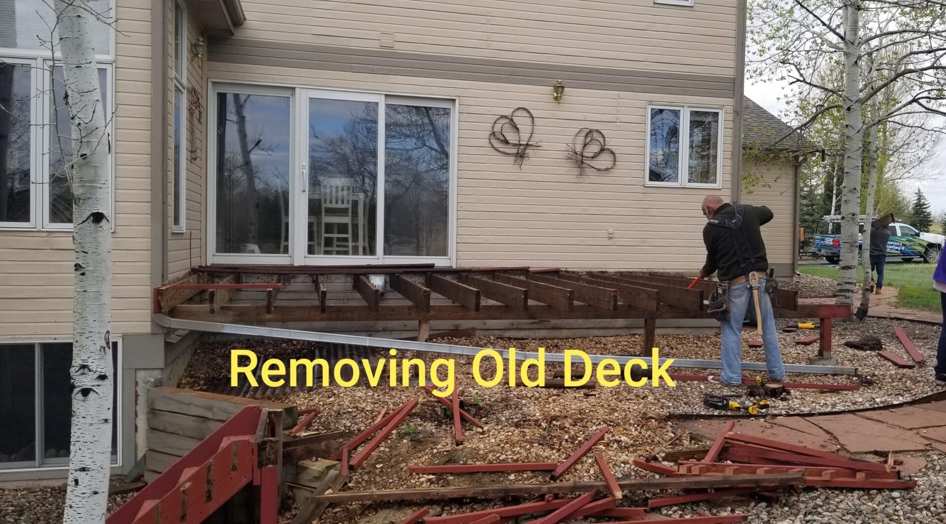 A man standing next to a pile of wood.