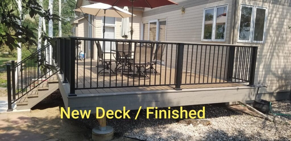 A deck with a metal railing and umbrella.
