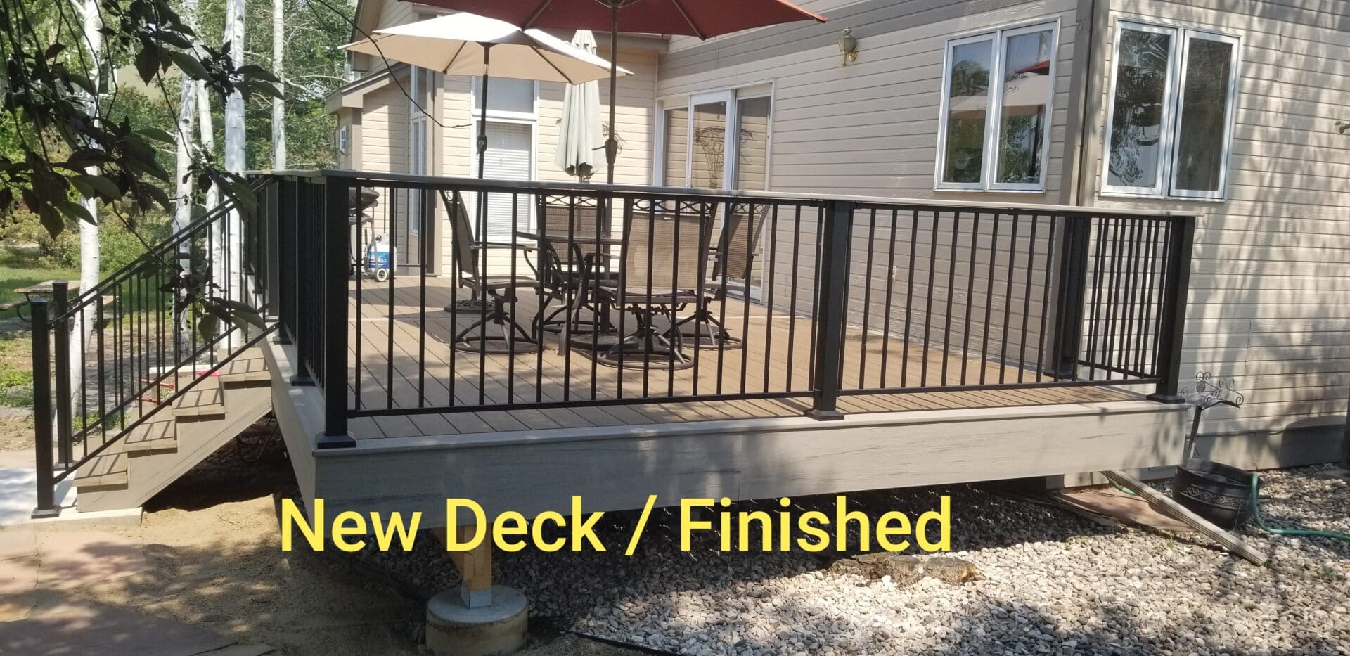 A deck with a metal railing and umbrella.