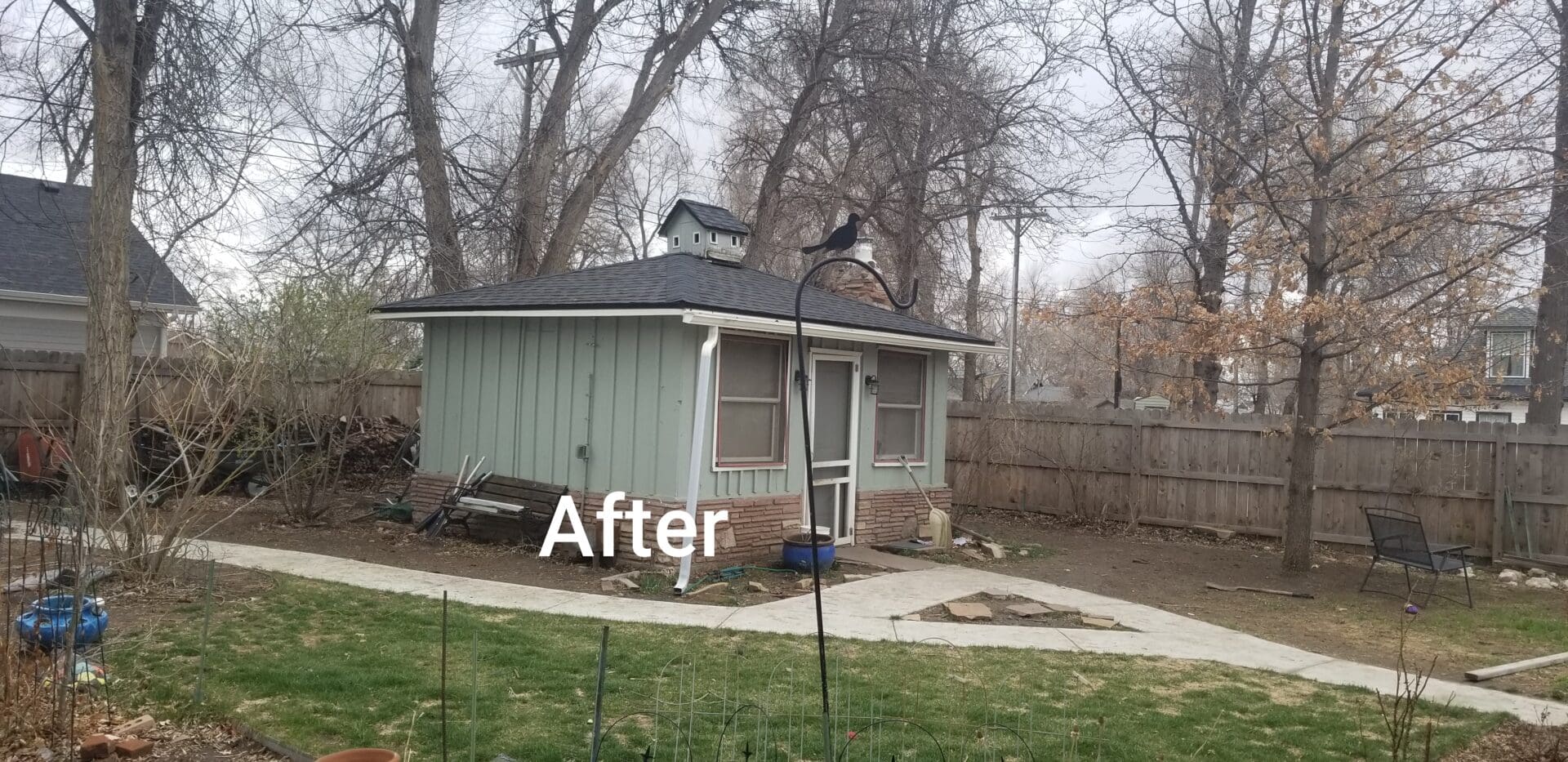 A backyard with a small green house.