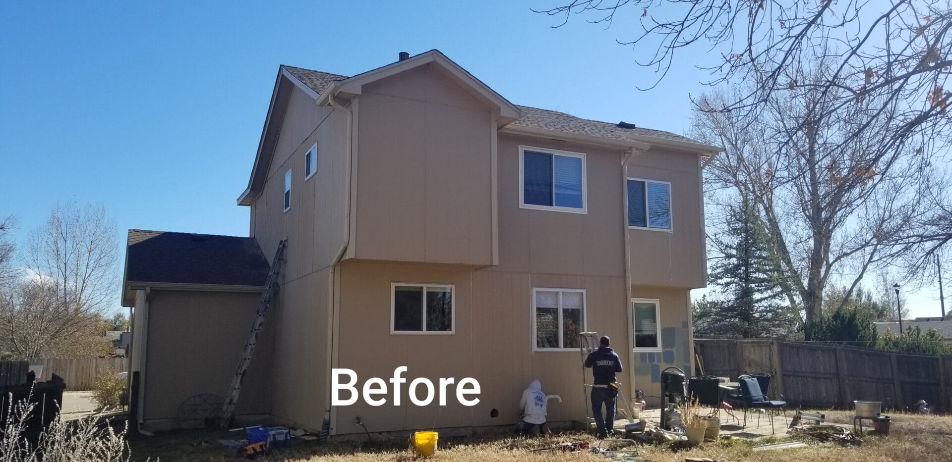 Back of a house with tan siding before painting.