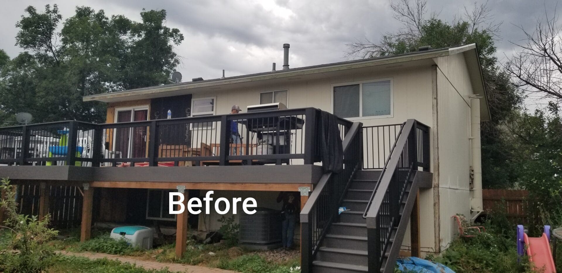 Back deck with stairs and railing before renovation.