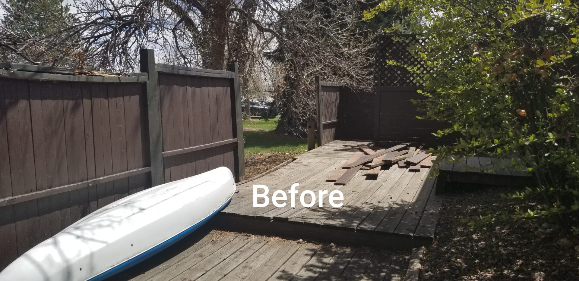 Wooden deck with a white canoe next to it.