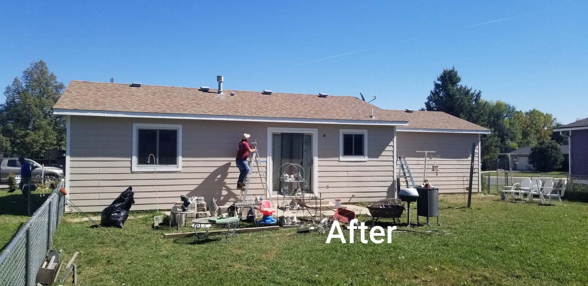 A man painting the exterior wall of a house.