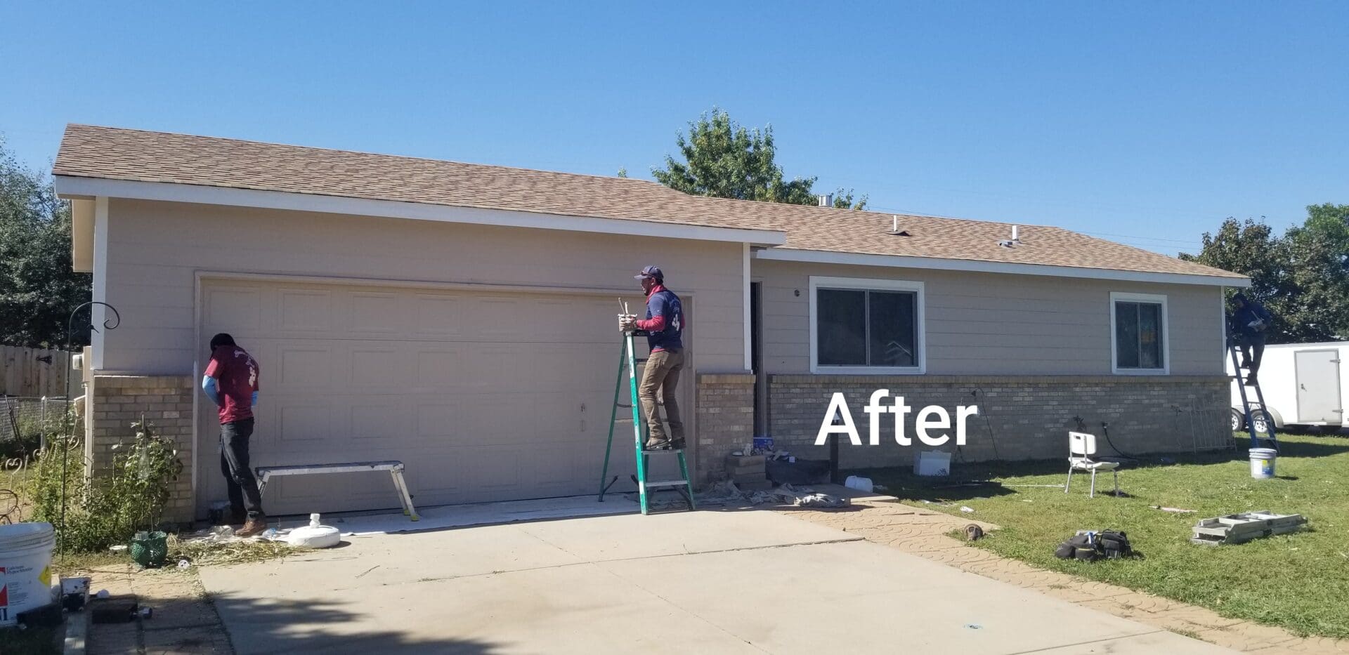 Two painters painting the exterior of a house.