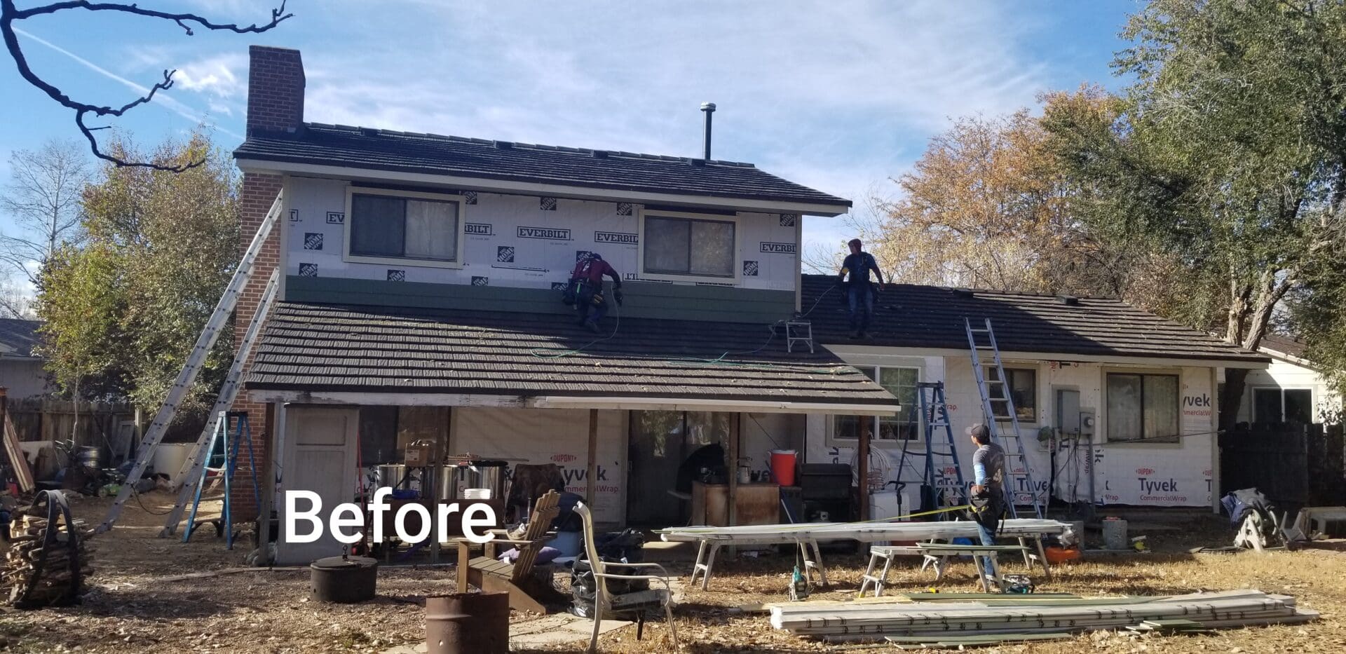 Two roofers on a roof before replacement.