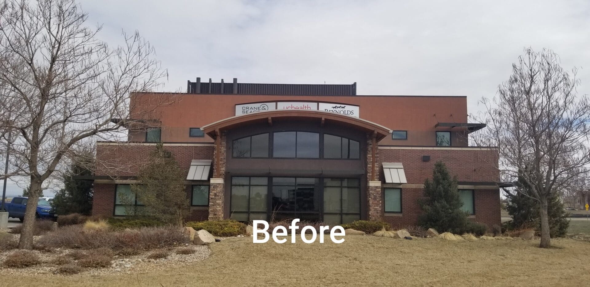 Front of a brown brick building with glass windows and doors.