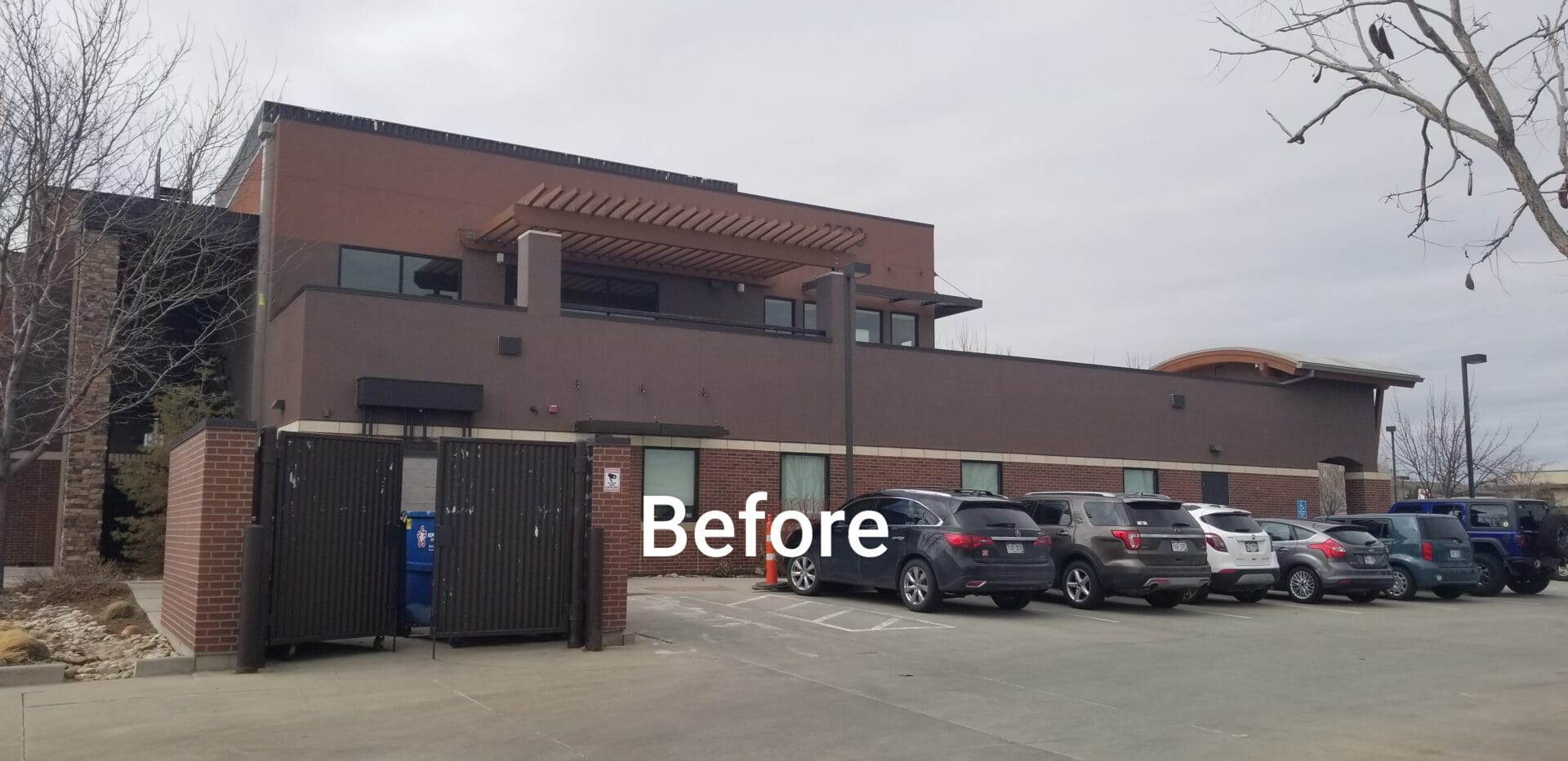 A brown commercial building with a parking lot.